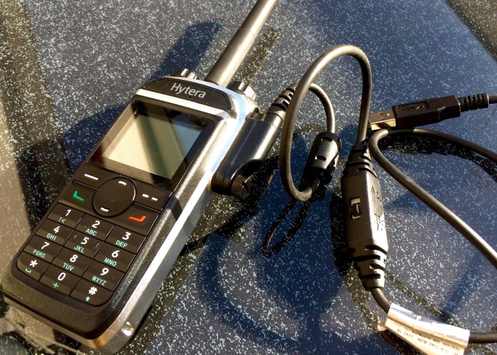 Das PD685 mit angeschraubtem Programmierkabel. Dieses hat einen Schalter, mit dem zwischen Upload neuer Firmware und Download/Upload des Codeplug umgeschaltet wird.